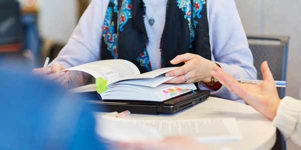 Book on a table being flipped through by a student.