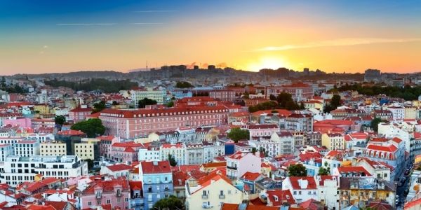 sunset over a town of bright coloured buildings in a portuguese-speaking country