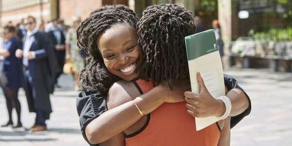 A female student hugs a family member on graduation day.