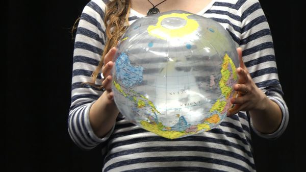 Female holding an inflatable globe in two hands