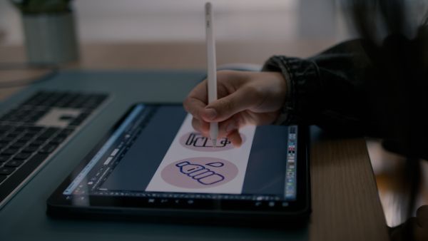 A person drawing on an ipad