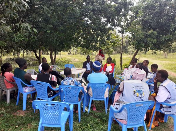 People involved in the project gather round on plastic seats