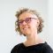 headshot of a white woman with short blond hair and glasses