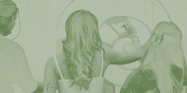 Film still showing three people and an artwork