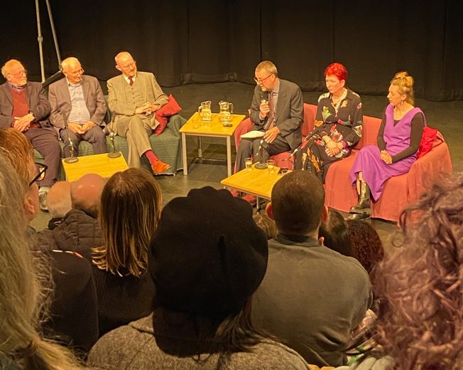 A group of people, including Mark Gatiss, in discussion on a stage 