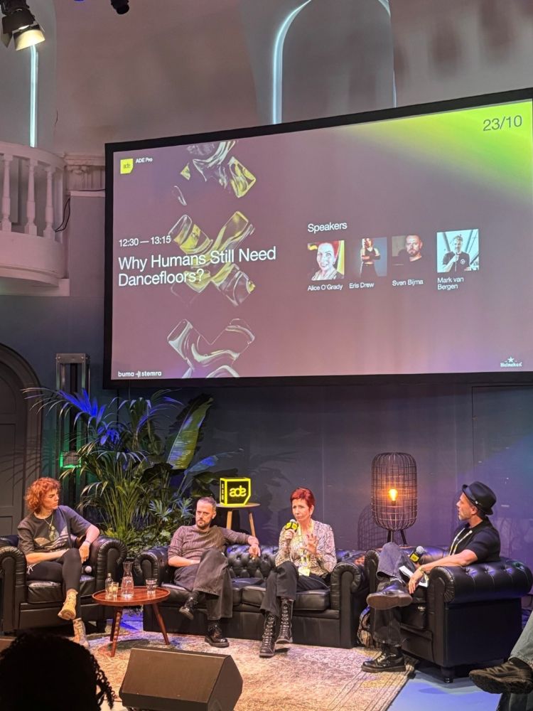 A group of people sit on a stage discussing why humans need dancefloors