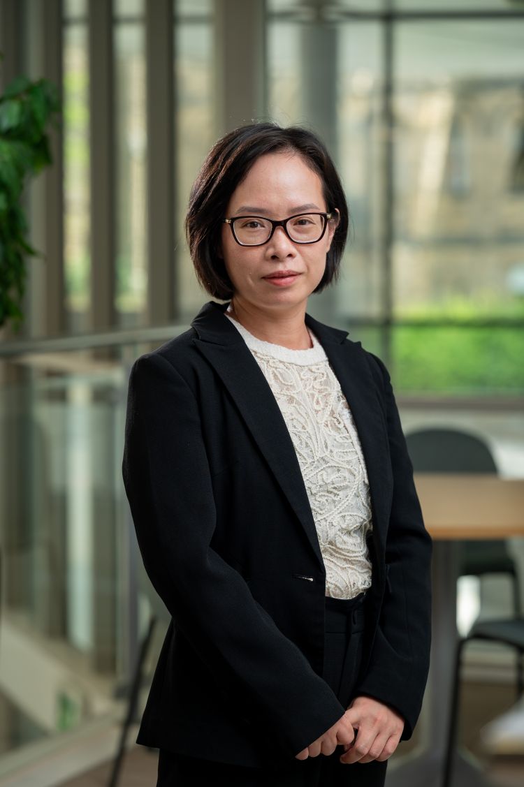 Profile photo of Thuy Thai, wearing black suit top.
