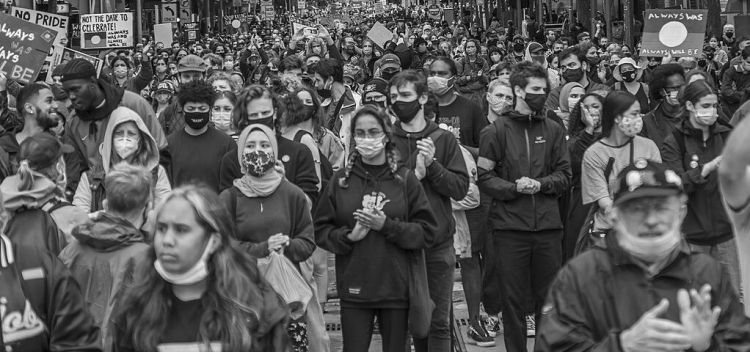A black and white photo of a crowd facing the lens
