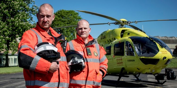 Two air ambulance workers next to helicopter