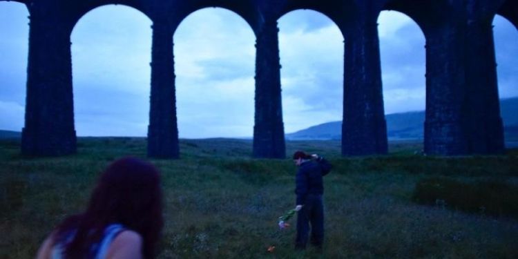 Ribblehead viaduct at dusk with two people in the foreground