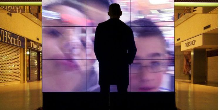 Person in front of a digital video installation in a shopping centre