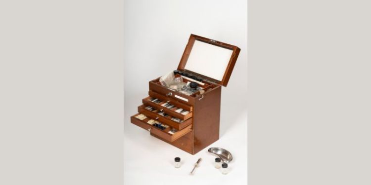 A wooden box containing dental instruments in small drawers, dating to the 1970s.