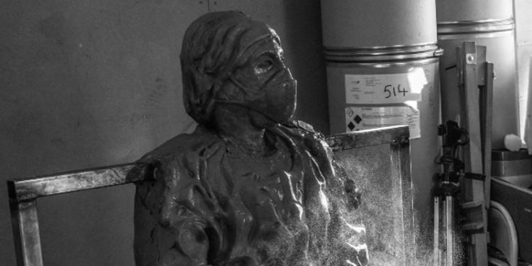 Black and white photo of part of a sculpture by Paul Digby entitled Looking to the Future of a nurse wearing a mask and protective clothing.