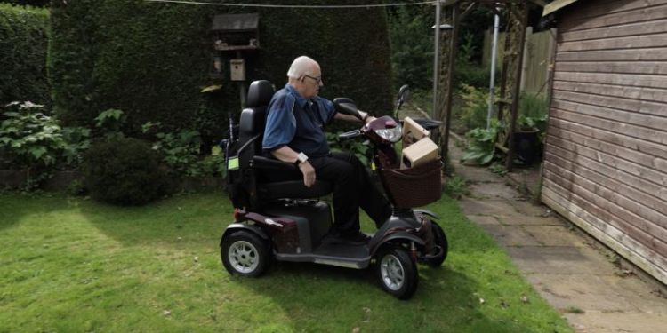 A man on his mobility scooter in a garden