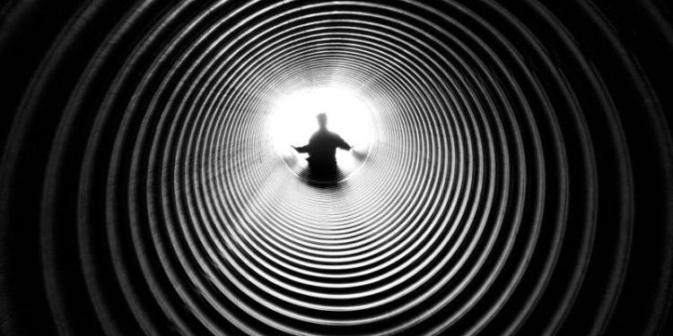 Black and white photo of a person at the end of a tunnel by Anthony DeRosa from Pexels