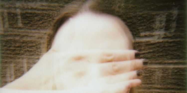 Blurred artistic portrait of a woman with hands covering face