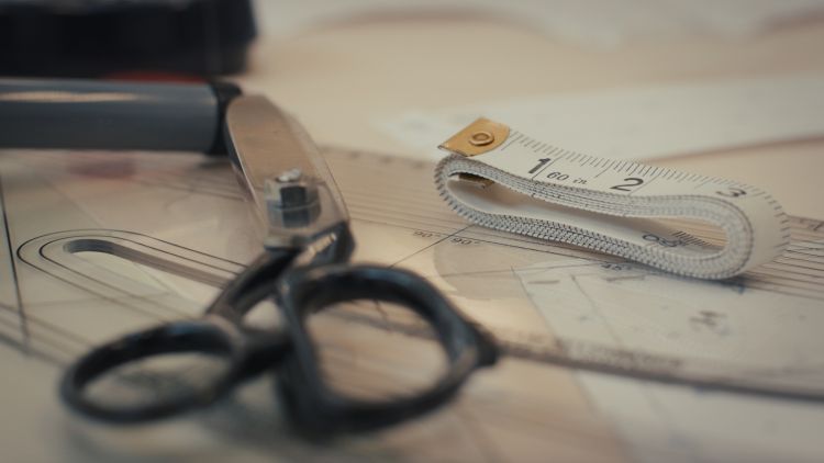 Pattern cutting tools on a table, scissors, fabric and cutters.