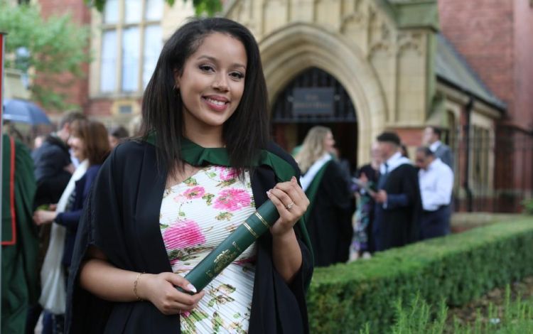 Fine art graduate outside the Great Hall on graduation day at the University of Leeds