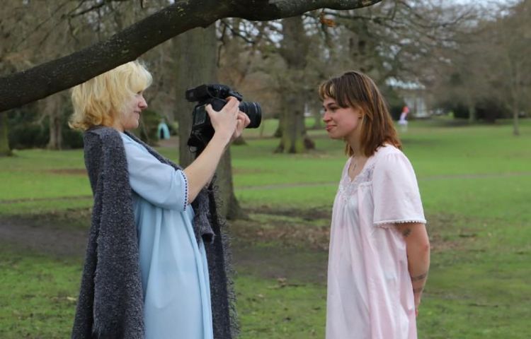 Two people in a park, one with a camera