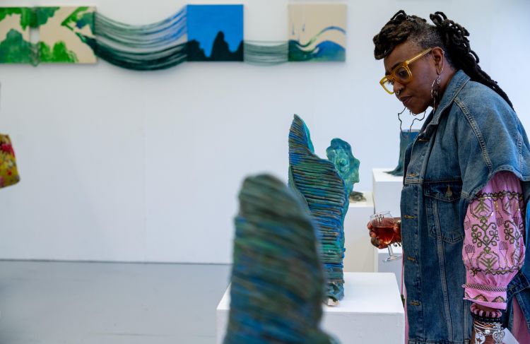 Visitor in a gallery views ceramic sculptures