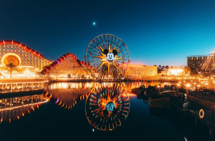 A photograph of an illuminated rollercoaster at night