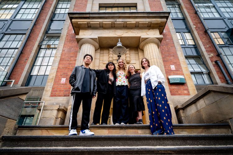 Five MA fine art students from the University of Leeds on the steps of their school building