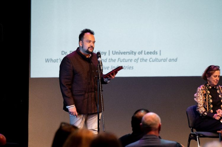 A man stands on a stage and speaks to an audience