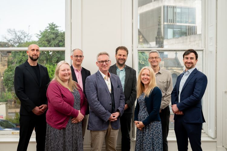 A group of people stand and smile for the camera
