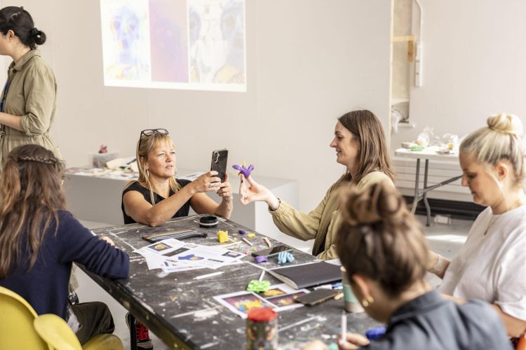 People taking part in an art workshop round a table