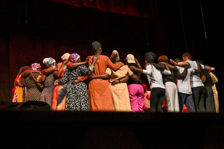 Group of actors huddled on a stage