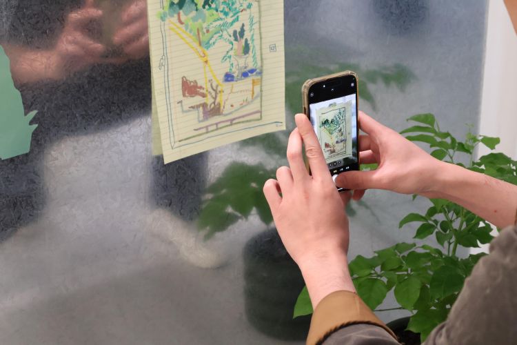 A person taking a photo of an artwork using their mobile phone