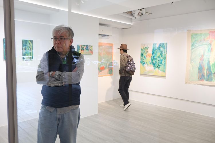Two visitors looking at artworks in a gallery