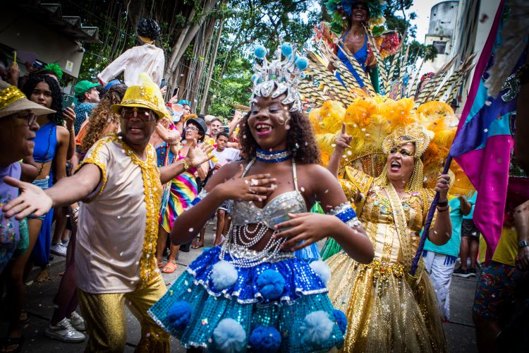 Dancers in bright and elaborate costumes celebrate in a lively carnival.