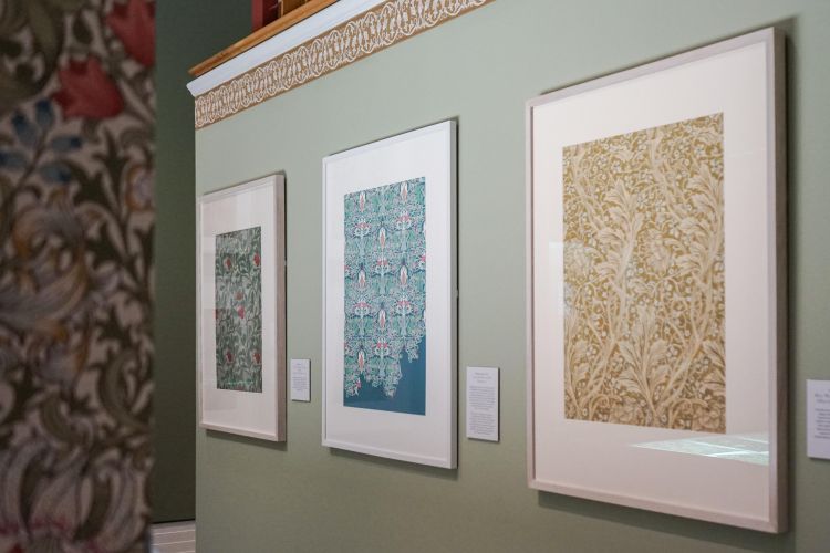 Three framed artworks on a gallery wall