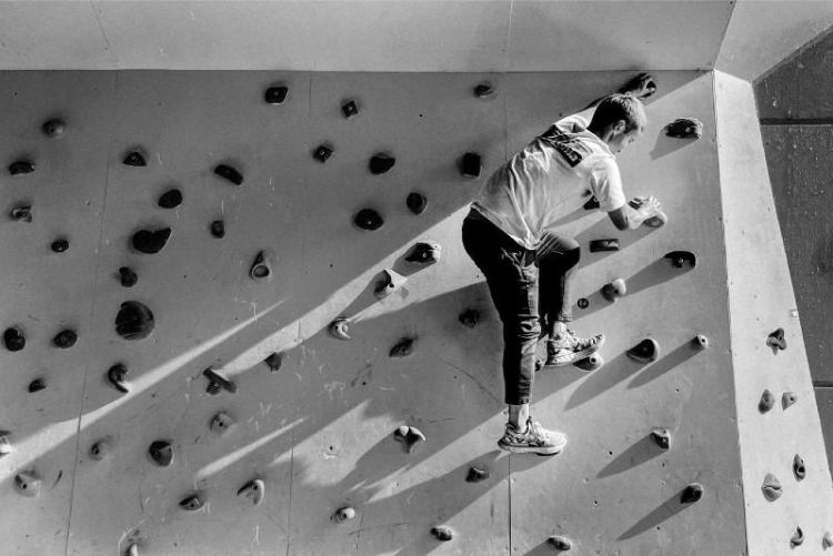 Black and white photo of a person on a climbing wall