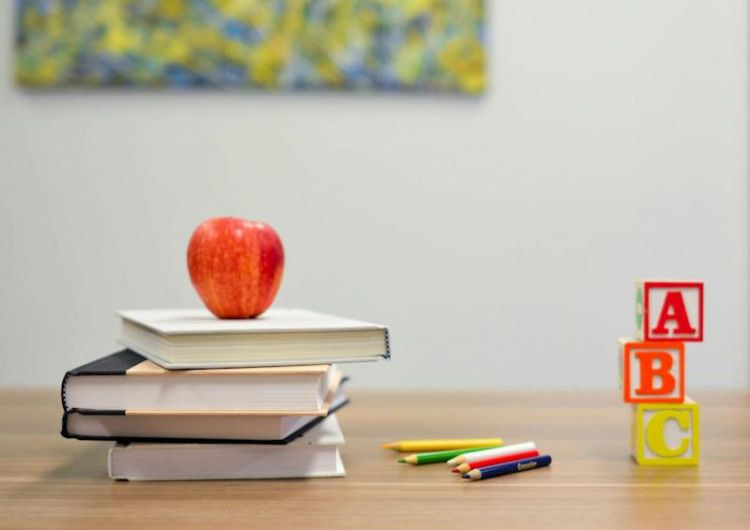 An image of an apple on some books