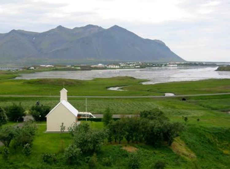 White chapel in cloudy rural landscape, colour