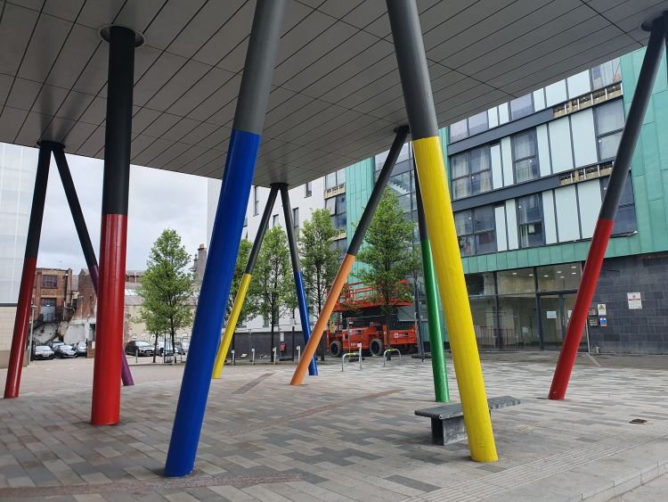 Image of public space courtyard with colourful poles