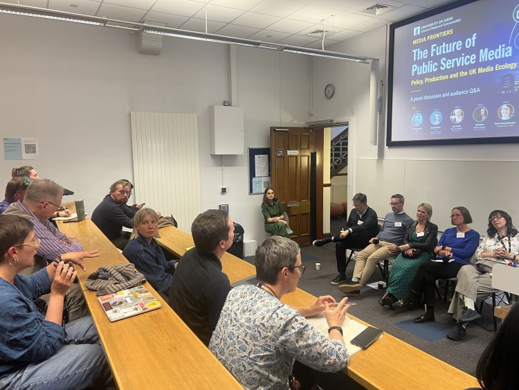 Audience members in a lecture theatre ask the panel questions