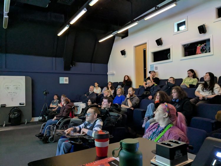 A group of people sit in seats in a cinema