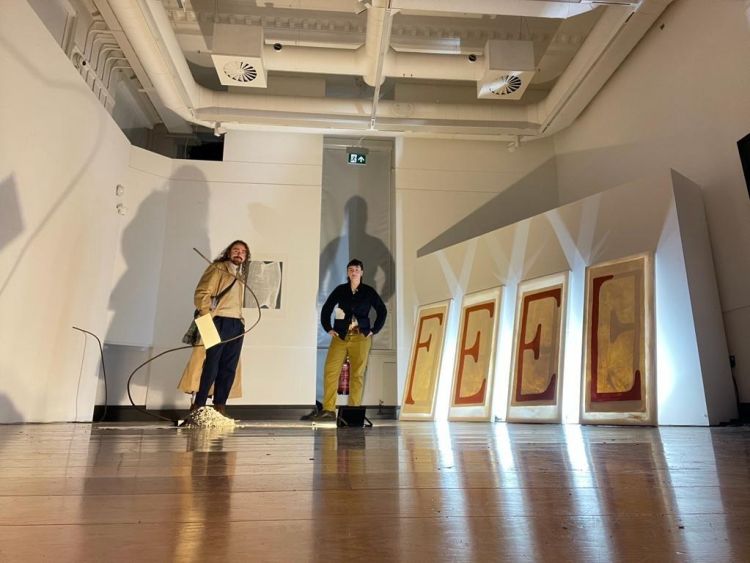 Artists Connor Shields and George Storm Fletcher in a gallery with their work