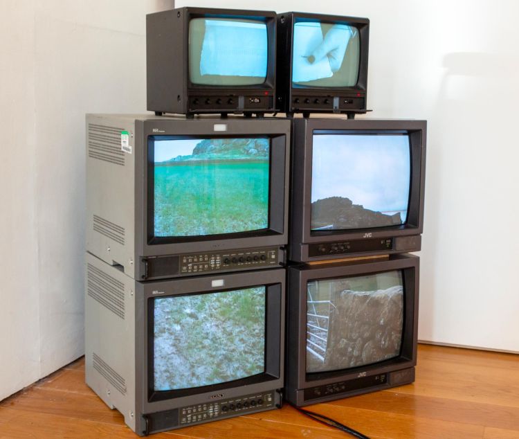 Six stacked crt monitors showing films