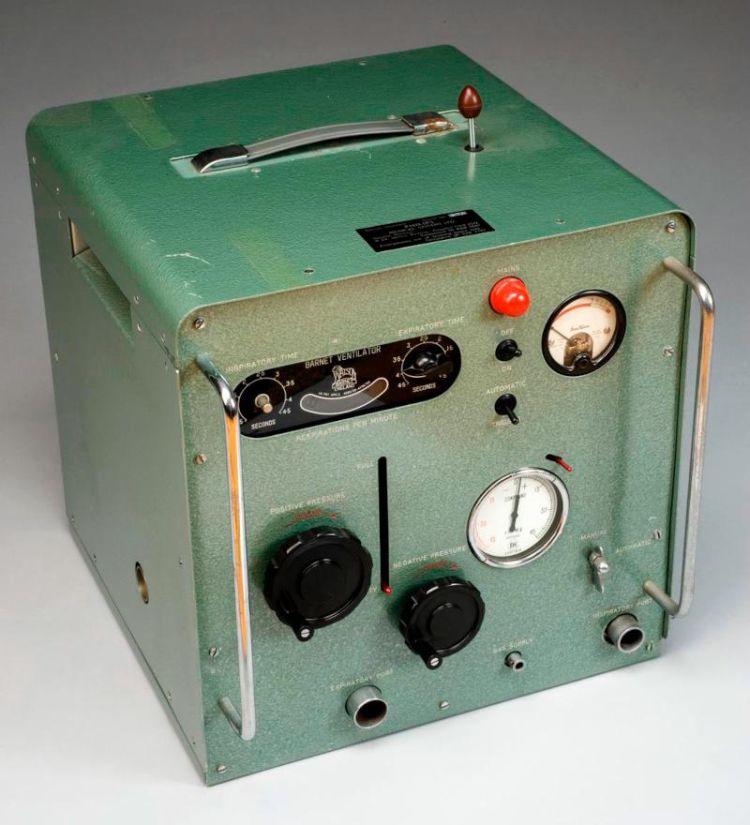 Light green Barnet Mark II ventilator, equipped with different mechanical controls, including dials, gauges, and a handle on top, set against a plain surface.