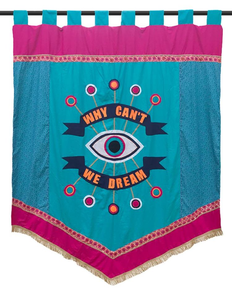 A colourful banner with a large central eye and the phrase &quot;WHY CAN&#039;T WE DREAM&quot; written in bold, orange letters. The banner, made as part of Living Life to the Fullest, features a turquoise background with pink accents and gold fringe.