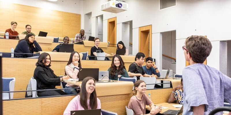 A number of students in the digital lecture theatre in the Roger Stevens Building, a lecturer stands at the front.