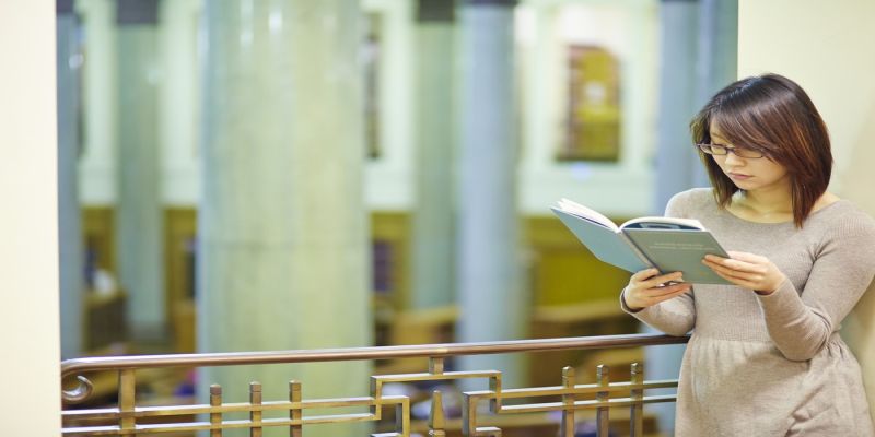 Female undergraduate reading a book in the Brotherton library