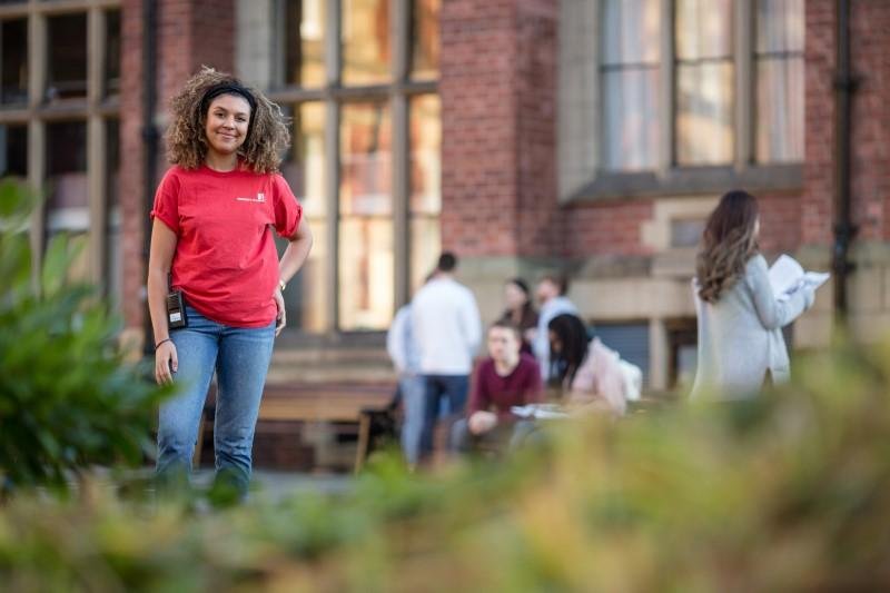 Student ambassador standing in front of campus buildings.