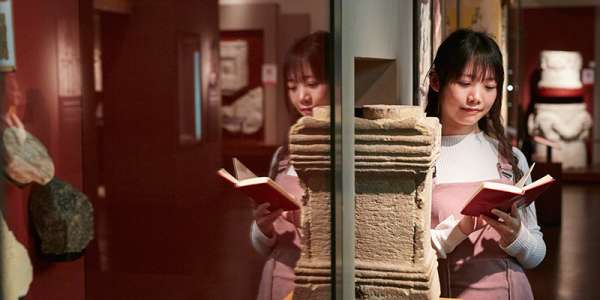Student in museum reading book