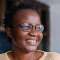 School of Fine Art, History of Art and Cultural Studies alumni, Laura Fungai Ganda. Laura is looking to the right of the frame and is smiling.