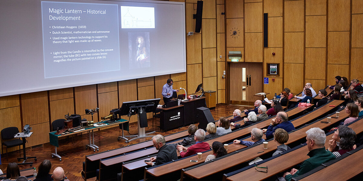 Interior of a lecture theatre with with a speaker and attendees